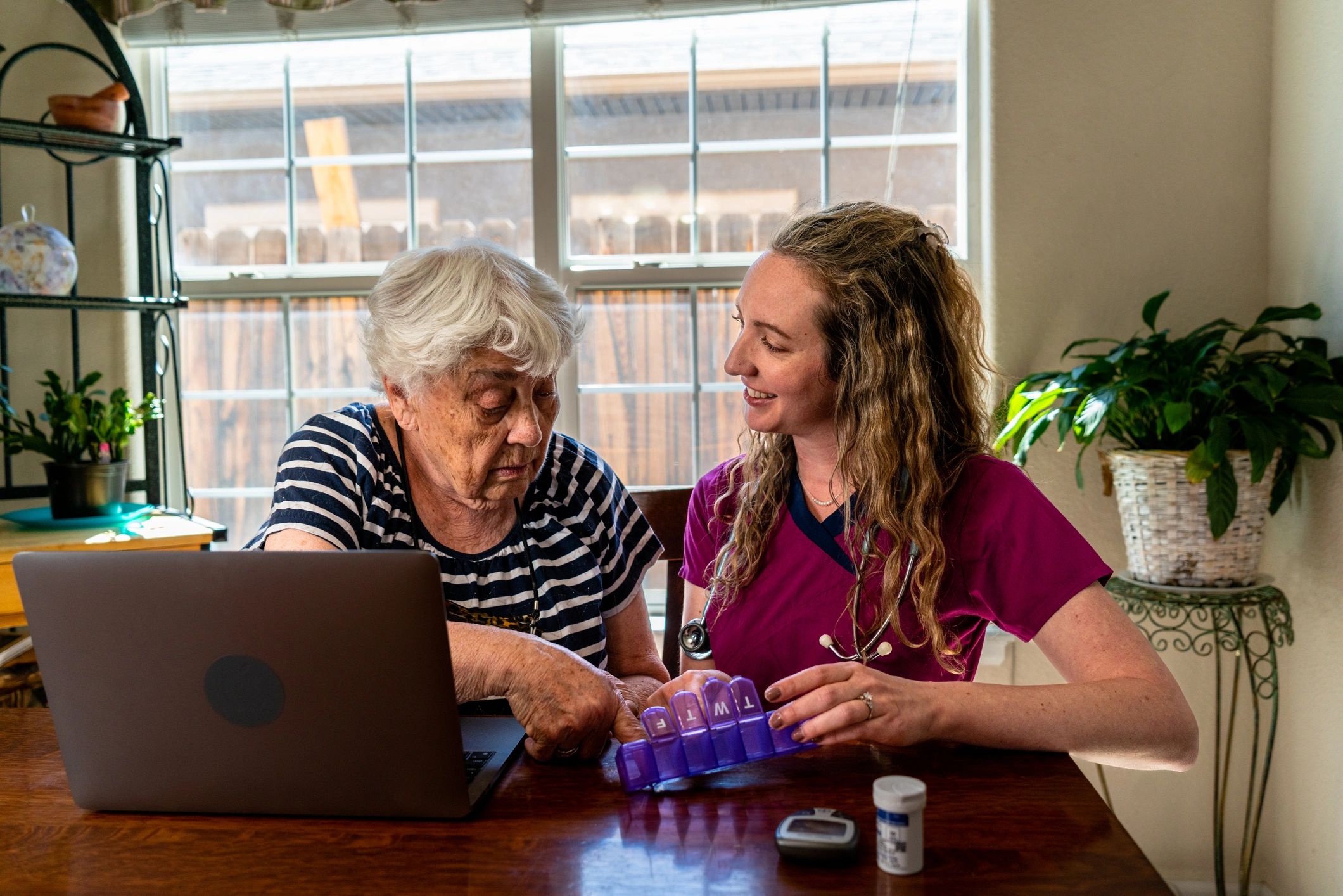 Nurse explaining daily medications to an elderly woman