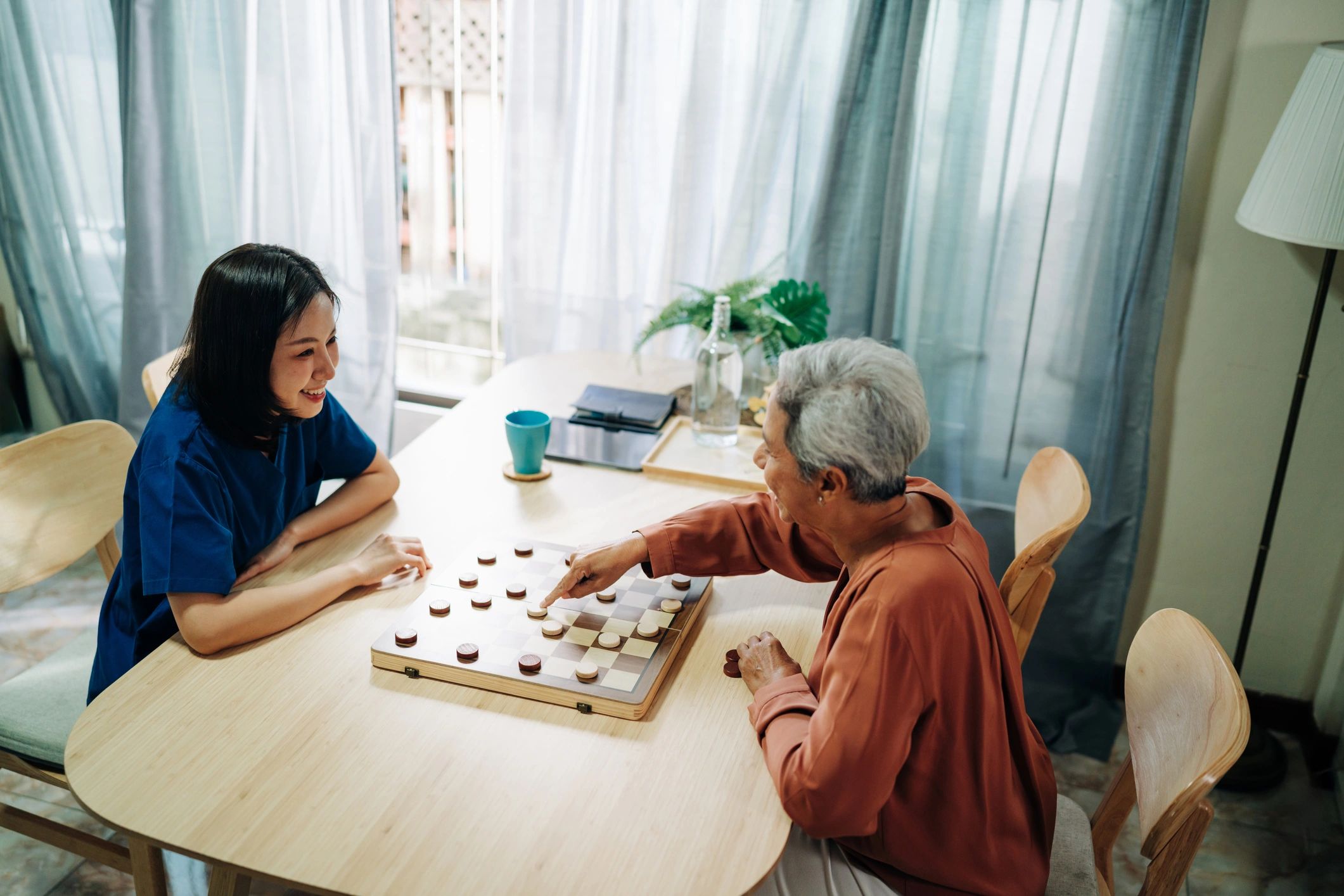 Caregiver spending quality time with an older person at home