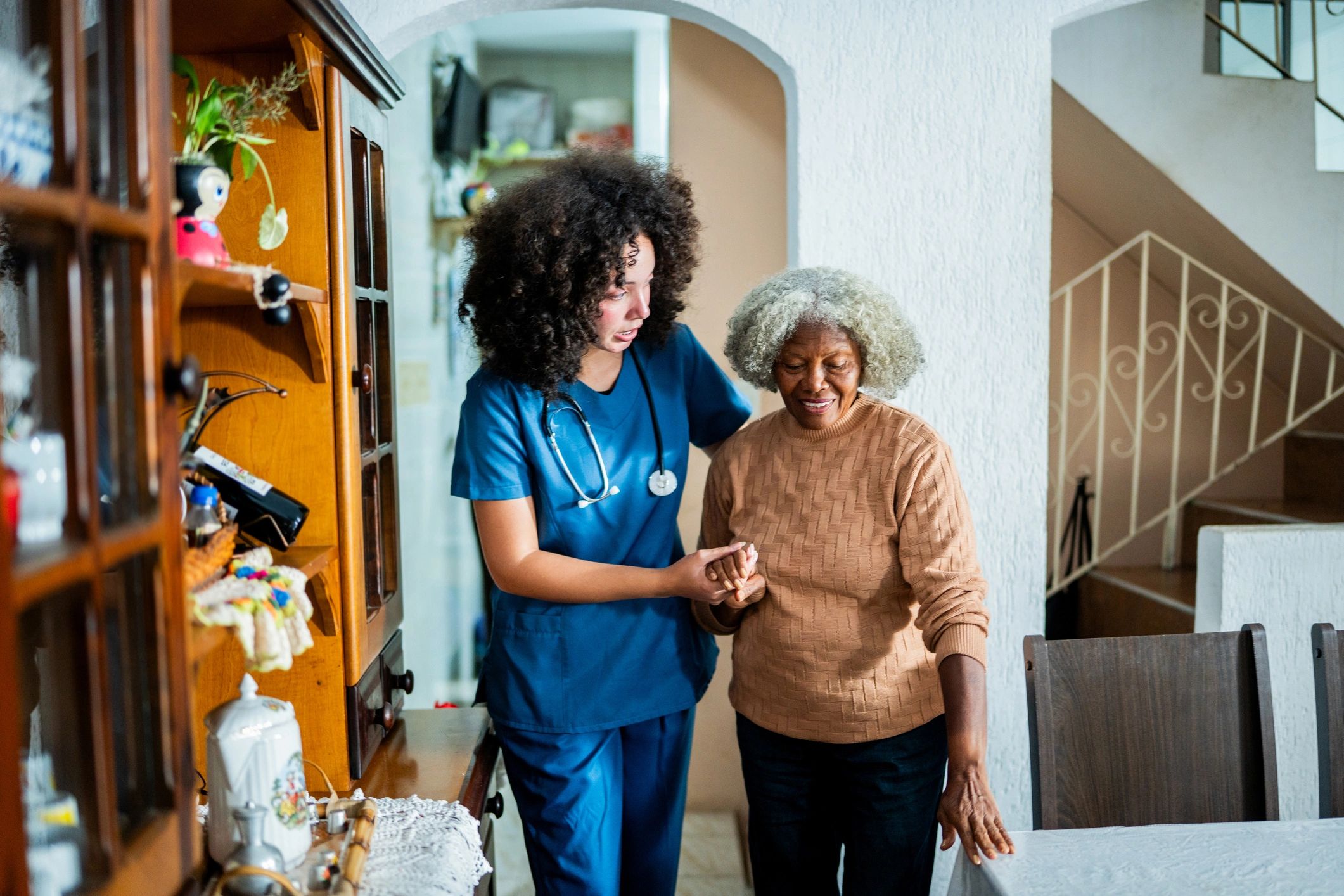 Caregiver helping an older person walk safely at home